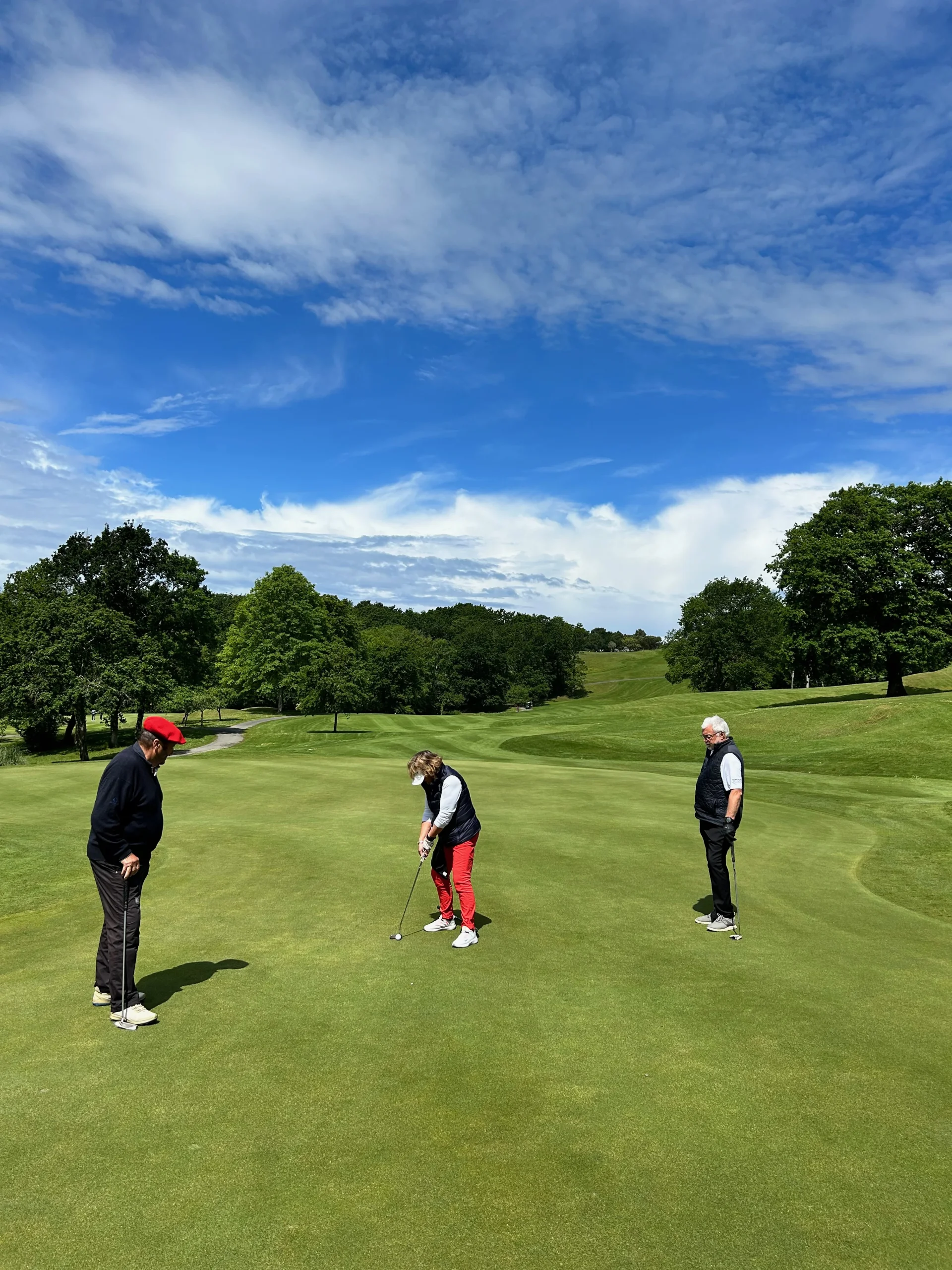 3 golfeurs putting